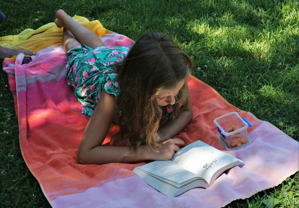 girl reading on a blanket