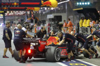 The crew for Red Bull driver Max Verstappen of the Netherlands push his car in pit lane during the first practice session at the Marina Bay City Circuit ahead of the Singapore Formula One Grand Prix in Singapore, Friday, Sept. 20, 2019. (AP Photo/Vincent Thian)