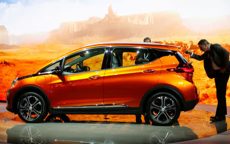 Show attendees look over a Chevrolet Bolt EV electric vehicle at the North American International Auto Show in Detroit, U.S. January 12, 2016. REUTERS/Gary Cameron