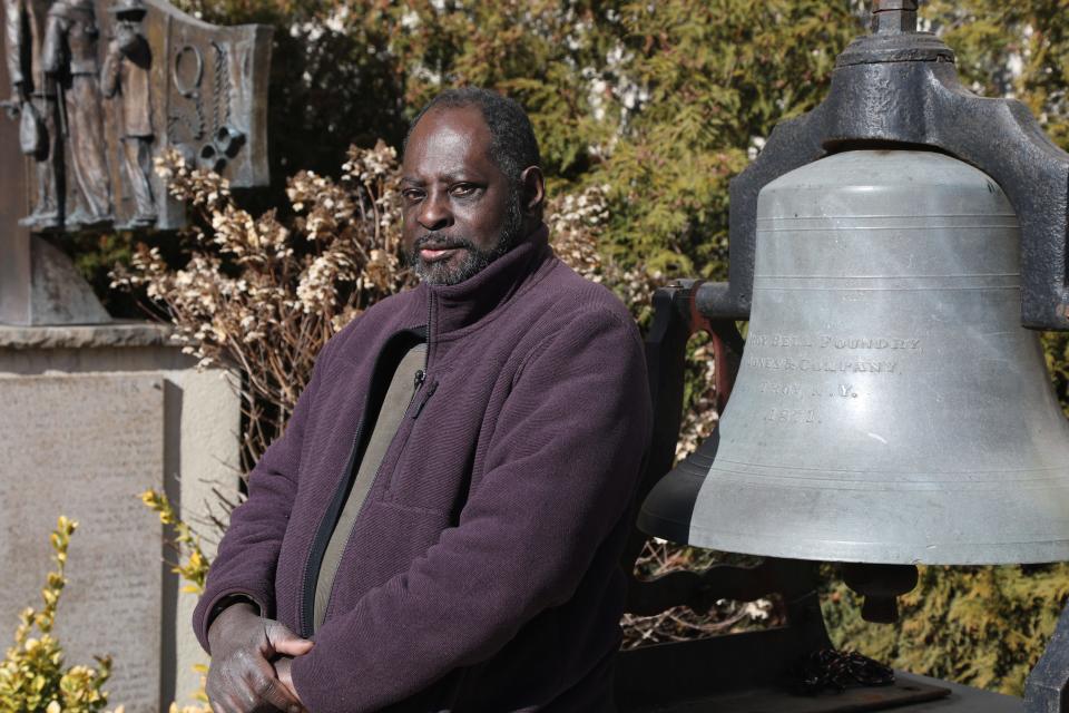 Historian Jimmy Richardson stands with the “Freedom Bell” in Paterson