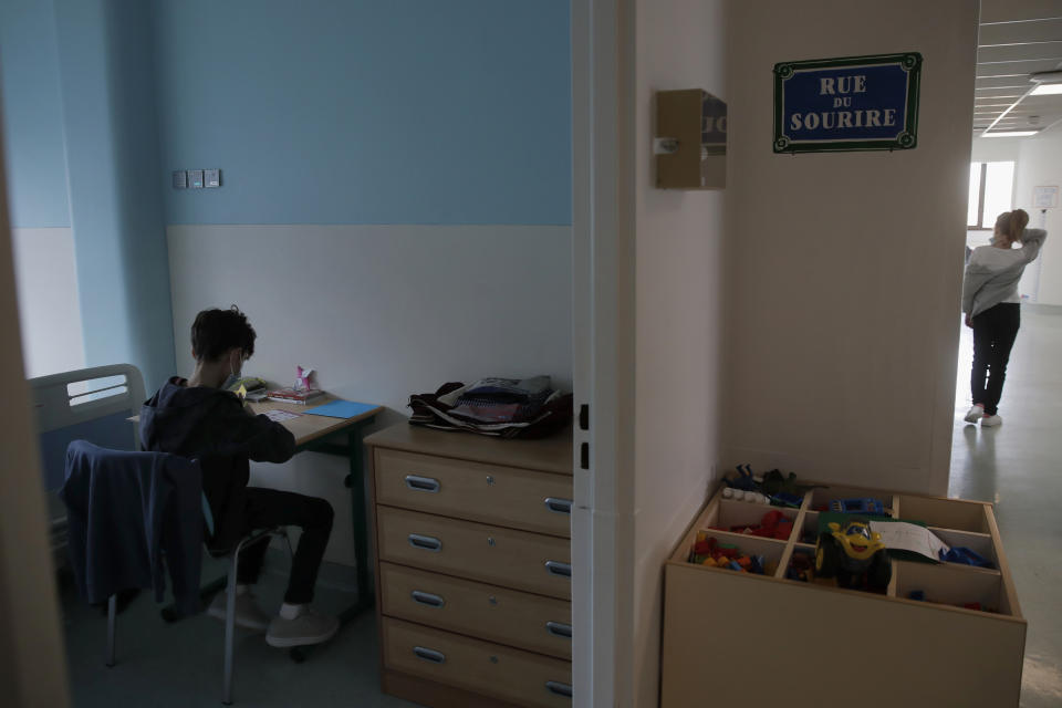 Pablo, 11, sits at the desk in his hospital room where he is being treated for severe eating disorders at the pediatric unit of the Robert Debre hospital, in Paris, France, Wednesday, March 3, 2021. By the time his parents rushed him to the hospital, 11-year-old Pablo was barely eating and had stopped drinking entirely. Weakened by months of self-privation, his heart had slowed to a crawl and his kidneys were faltering. Medics injected him with fluids and fed him through a tube — first steps toward stitching together yet another child coming apart amid the tumult of the coronavirus crisis. (AP Photo/Christophe Ena)