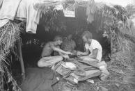 FILE - Music fans seek shelter in a grass hut at the Woodstock Music and Art Festival in Bethel, N.Y., Aug. 17, 1969. The sign above reads "Have a Marijuana." Marijuana advocates are gearing up for Saturday, April 20, 2024. Known as 4/20, marijuana's high holiday is marked by large crowds gathering in parks, at festivals and on college campuses to smoke together. Medical marijuana is now legal in 38 states. (AP Photo/File)