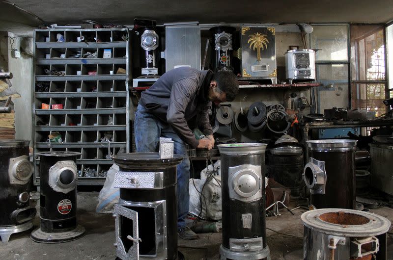 A man works inside a workshop which produces heaters in Hama