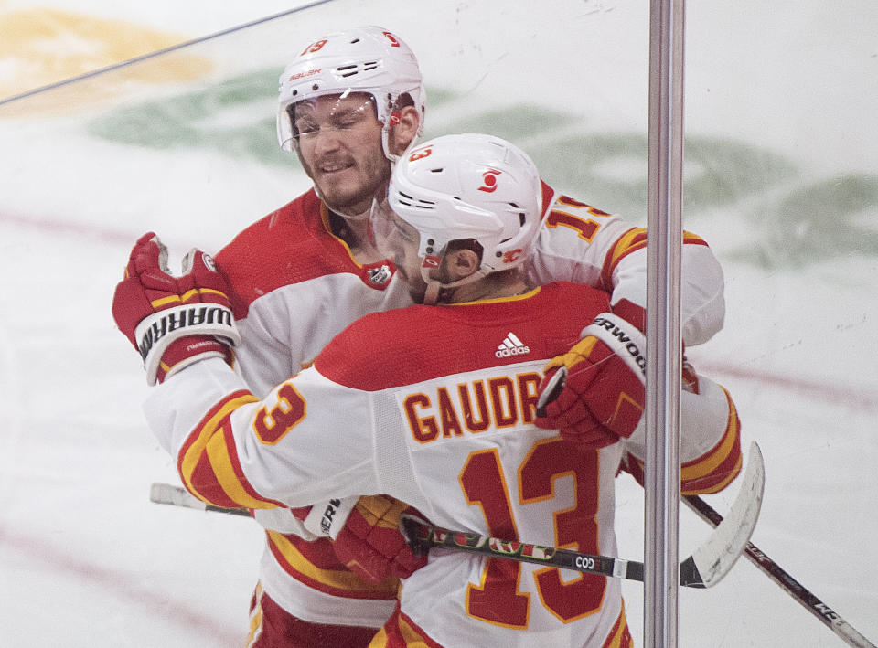 Calgary Flames' Johnny Gaudreau (13) celebrates with teammate Matthew Tkachuk (19) after scoring against the Montreal Canadiens during first-period NHL hockey game action in Montreal, Saturday, Jan. 30, 2021. (Graham Hughes/The Canadian Press via AP)