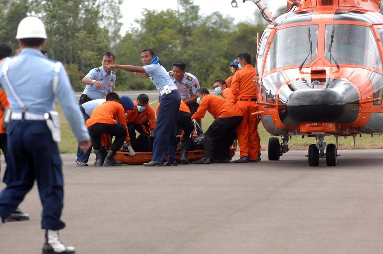 Members of an Indonesian search and rescue team prepare to carry a dead body during the recovery of victims who were onboard the crashed AirAsia flight QZ8501 in Pangkalan Bun on December 31, 2014