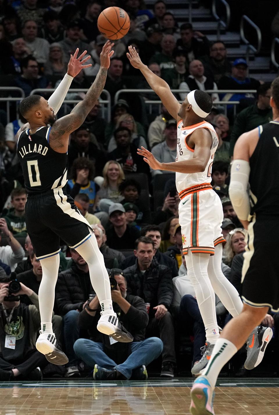 Milwaukee Bucks guard Damian Lillard (0) shoots over San Antonio Spurs guard Malaki Branham (22) during the first half of their game Tuesday, December 19, 2023 at Fiserv Forum in Milwaukee, Wisconsin.