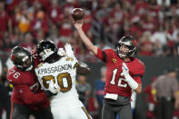 Tampa Bay Buccaneers quarterback Tom Brady (12) passes under pressure from New Orleans Saints defensive end Tanoh Kpassagnon (90) in the first half of an NFL football game in Tampa, Fla., Monday, Dec. 5, 2022. (AP Photo/Chris O'Meara)