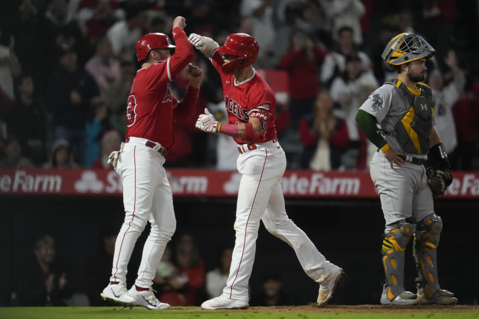 Los Angeles Angels' Logan O'Hoppe (14) celebrates with Brandon Drury, left, after hitting a home run during the seventh inning of a baseball game against the Oakland Athletics in Anaheim, Calif., Saturday, Sept. 30, 2023. Drury also scored. (AP Photo/Ashley Landis)