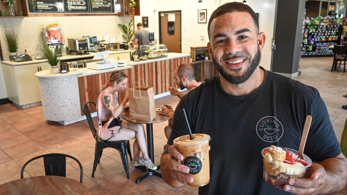 Justin Henry, owner of Loving Seed, holds a cold brew and açai bowl from the cafe which recently opened a fixed location inside the Fresno Elite Car Wash on Herndon and West avenues in north Fresno.
