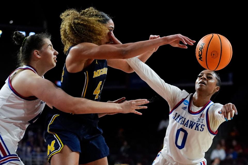 Michigan forward Cameron Williams (44) and Kansas guard Wyvette Mayberry (0) reach for a loose ball during a first-round NCAA tournament game at Galen Center in Los Angeles on Saturday, March 23, 2024.