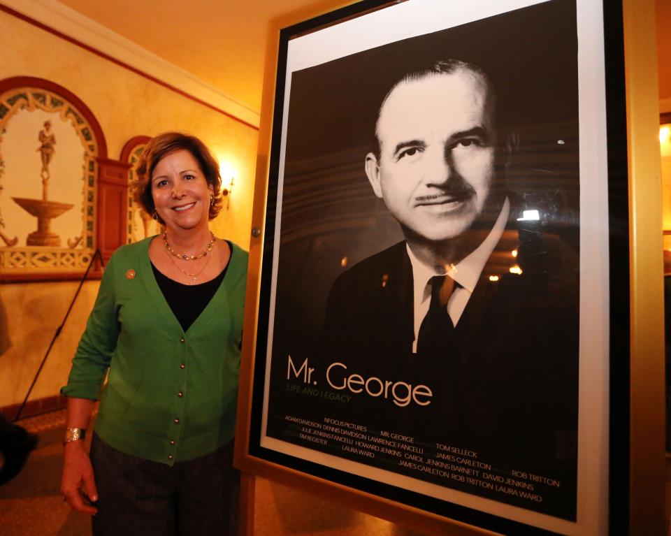 Carol Jenkins Barnett, George Jenkins' daughter and president of Publix Super Markets Charities, stands next to a movie poster for Mr. George at the Polk Theatre during the premier for the movie in 2014 in Lakeland.