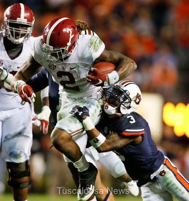 Alabama running back Derrick Henry (2) runs through a tackle by Auburn defensive back Jonathan Jones (3) during Alabama's 29-13 win over Auburn during the 2015 Iron Bowl in Auburn. Henry rushed for 271 yards during the contest. Staff Photo | Gary Cosby Jr.