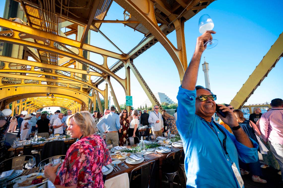 Guneet Bajwa of Presidio Companies, owner of Hyatt hotels including the Hyatt Centric Downtown Sacramento, holds up his glass while trying to find a guests at the Farm-to-Fork Festival’s Tower Bridge Dinner on Sunday.