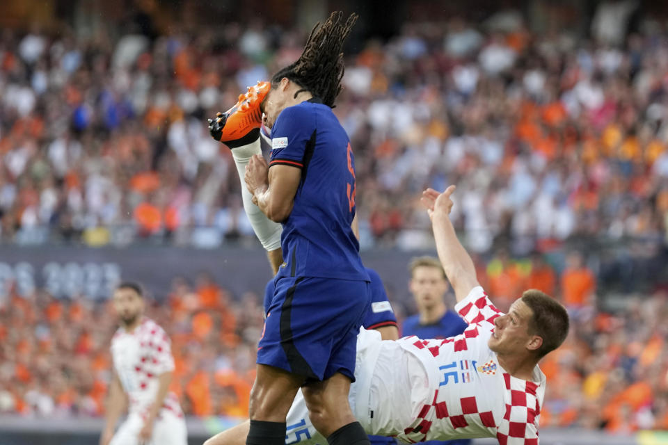 Croatia's Mario Pasalic hits Netherlands' Nathan Ake in the face, and gets a yellow card for it, during the Nations League semifinal soccer match between the Netherlands and Croatia at De Kuip stadium in Rotterdam, Netherlands, Wednesday, June 14, 2023. (AP Photo/Peter Dejong)