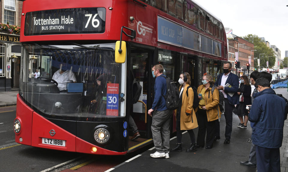 People board a bus outside Waterloo station in London, Wednesday, Sept. 23, 2020, after Prime Minister Boris Johnson announced a range of new restrictions to combat the rise in coronavirus cases in England, Wednesday, Sept. 23, 2020. (Dominic Lipinski/PA via AP)