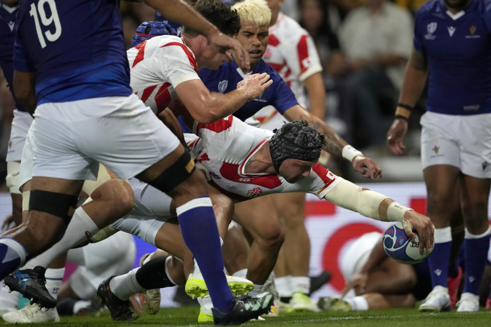 Japan's Pieter Labuschagne, centre, scores a try during the Rugby World Cup Pool D match between Japan and Samoa, at the Stadium de Toulouse in Toulouse, France, Thursday, Sept. 28, 2023. (AP Photo/Christophe Ena)