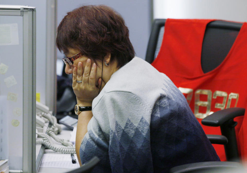 A floor trader studies stock price at the Hong Kong Stock Exchange Friday, May 11, 2012. Asian stock markets were lower Friday as traders eyed political upheaval in Greece and signs of slowing economic growth in China. Hong Kong's Hang Seng fell 1.2 percent to 19,989.54. (AP Photo/Kin Cheung)