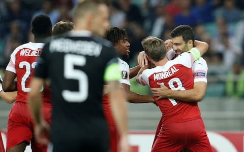 Arsenal captain Nacho Monreal grabs goalscorer Sokratis Papastathopoulos in a celebratory bear hug - Credit: REUTERS/David Mdzinarishvili