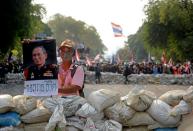 A Thai anti-government protestor holds a poster of King Bhumibol Adulyadej during a stand-off with police near Government House in Bangkok, on February 18, 2014