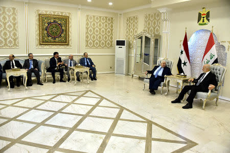 Iraq's Foreign Minister Ibrahim al-Jaafari (R) meets with his Syrian counterpart Walid al-Muallem at Baghdad airport August 25, 2016. Iraqi Foreign Minister Office/Handout via REUTERS