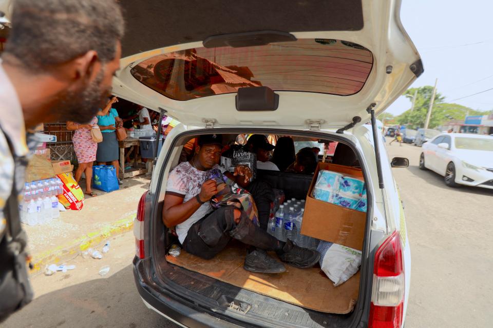 A man sits in the back of a car loaded with supplies in Kingston, Jamaica on Tuesday ahead of Hurricane Beryl (REUTERS)