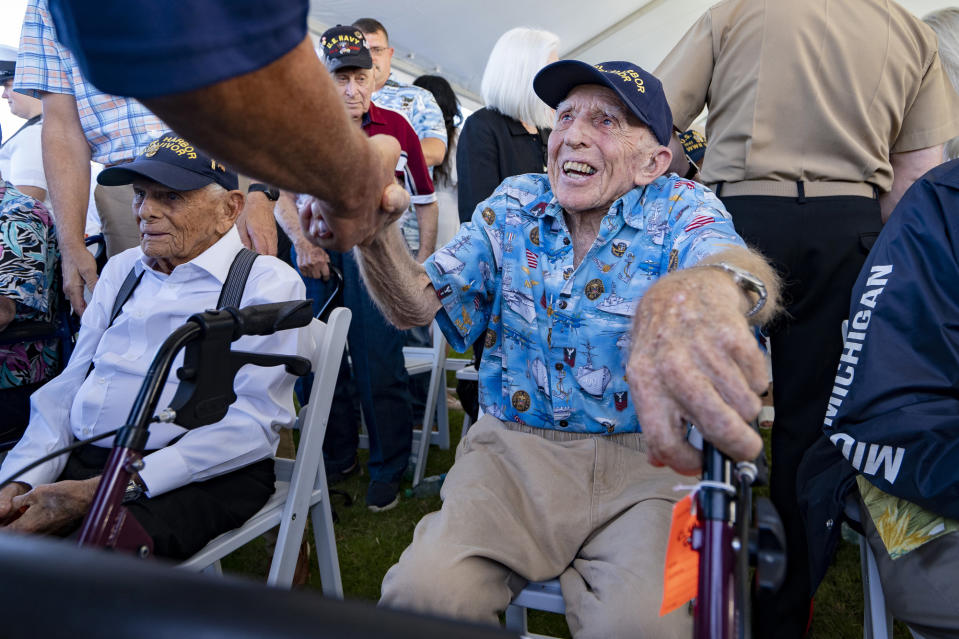 Pearl Harbor survivor Ken Stevens, shakes hand with an attendee during the 82nd Pearl Harbor Remembrance Day ceremony on Thursday, Dec. 7, 2023, at Pearl Harbor in Honolulu, Hawaii. (AP Photo/Mengshin Lin)