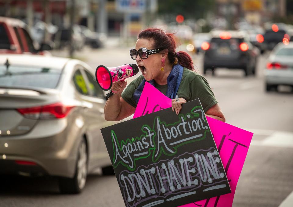 Bonnie Patterson James shouts into a megaphone as she protests the Supreme Court decision overturning Roe V Wade on South Florida Avenue in Lakeland on Friday.