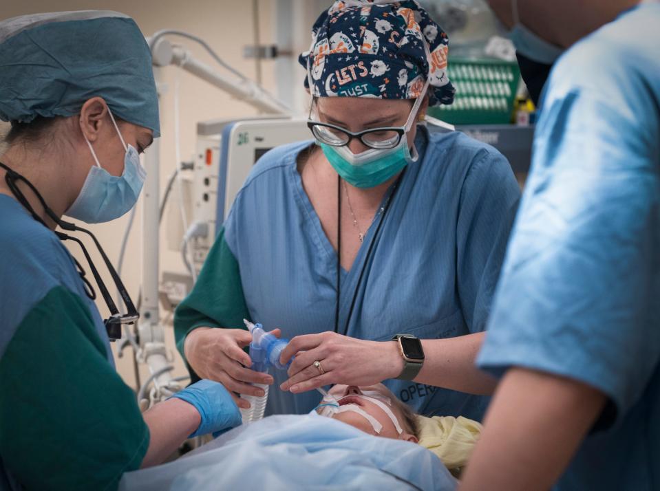 Gina Sacks, 32, chief resident of plastic surgery at the University of Michigan, left, helps to prepare Yelizaveta Nadolniak, 4 of Mykolaiv, Ukraine for surgery with Whitney Roberts, a certified nurse anesthetist from Boston Children’s Hospital at the Public Health Care Facility in Leczna, Poland on Tuesday, May 16, 2023. 