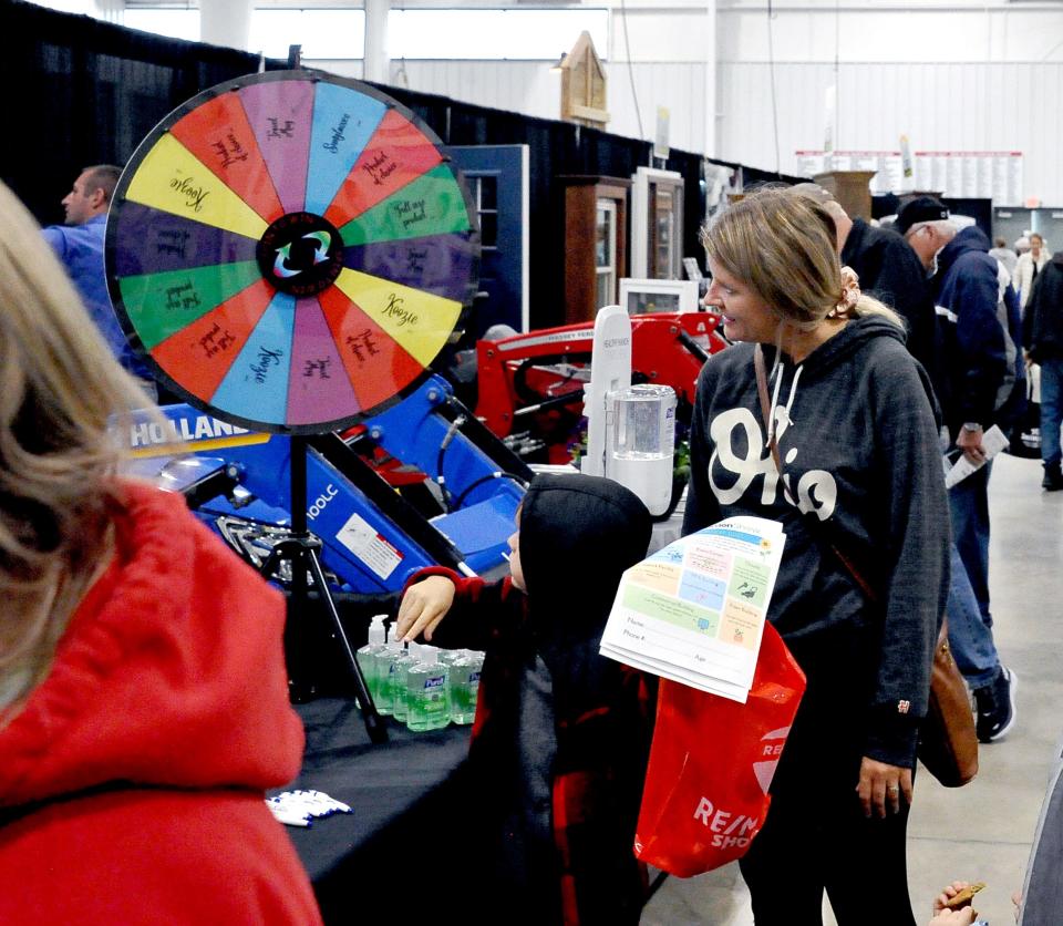 Sterling Winningham spins the prize wheel at the GOJO booth at the Home and Garden Show as mom Elizabeth watches.