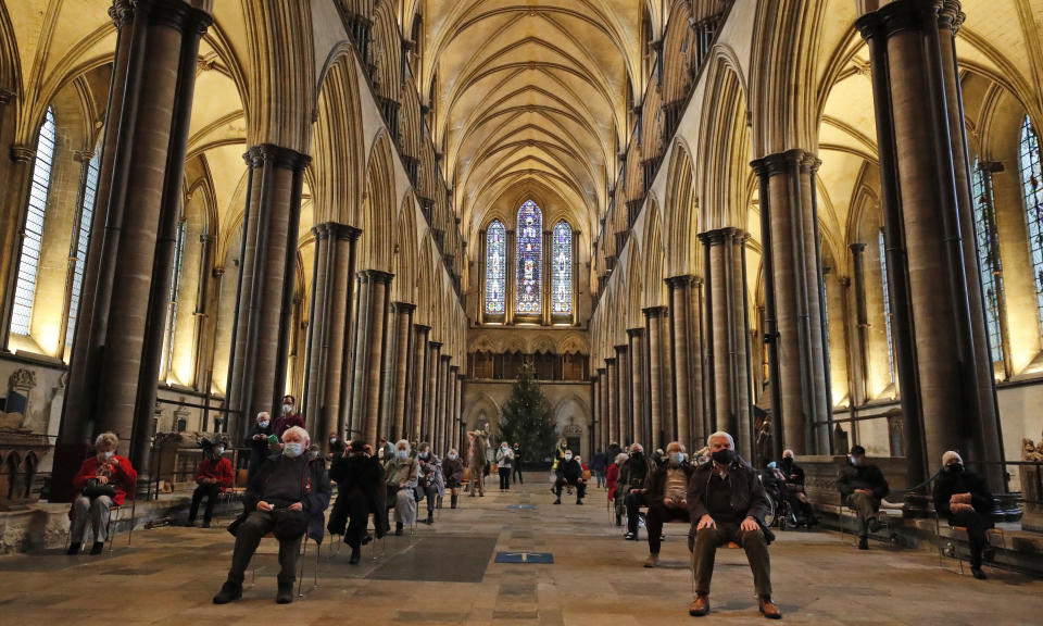 People sit and relax after receiving their Pfizer-BioNTech vaccination at Salisbury Cathedral in Salisbury, England, Wednesday, Jan. 20, 2021. Salisbury Cathedral opened its doors for the second time as a venue for the Sarum South Primary Care Network COVID-19 Local Vaccination Service. (AP Photo/Frank Augstein)