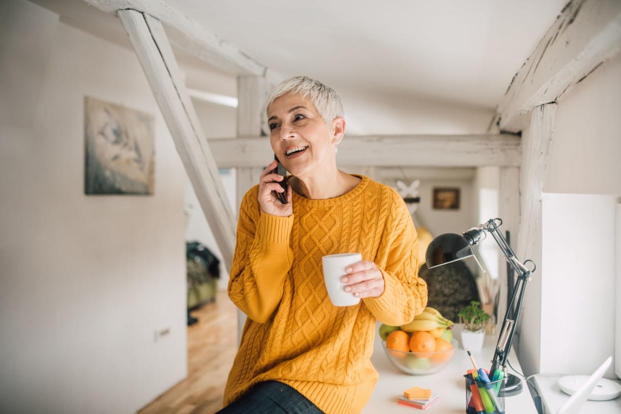 Happy senior woman using her mobile phone and smiling