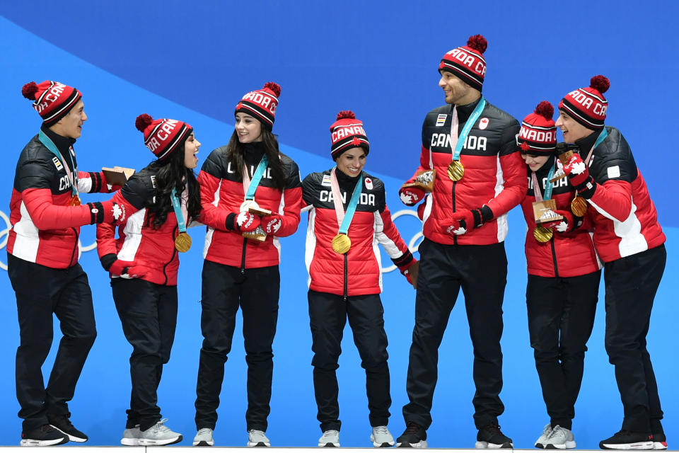 Canada's gold medal-winning team celebrate on the podium during the medal ceremony for the figure skating team event on Feb. 12, 2018. | Fabrice Coffrini—AFP/Getty Images: