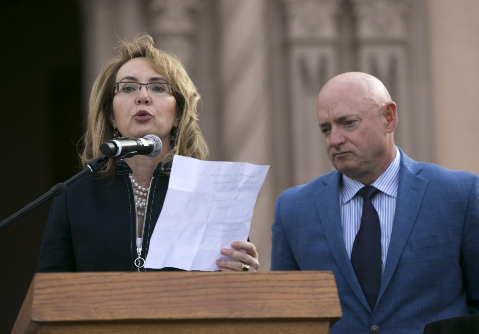 Former U.S. Rep. Gabrielle Giffords speaks, as her husband, Mark Kelly looks on, during the memorial dedication for Tucson's January 8th Memorial at El Presidio Park in Tucson on Jan. 8, 2018. The dedication was held on the seven-year anniversary of the Tucson-area mass shooting that left six people dead and 13 others injured, including Giffords. The memorial is expected to be completed within the next two years.
