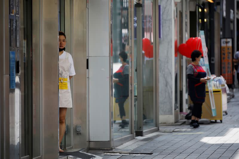 A shop assistant waits for a customer at Myeongdong shopping district which is nearly empty amid the coronavirus disease (COVID-19) pandemic in Seoul