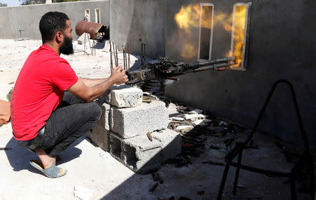 FILE PHOTO: A fighter loyal to Libyan internationally recognised government fires a heavy machine gun during clashes with forces loyal to Khalifa Haftar at outskirts of Tripoli, Libya May 16, 2019. REUTERS/Goran Tomasevic/File Photo