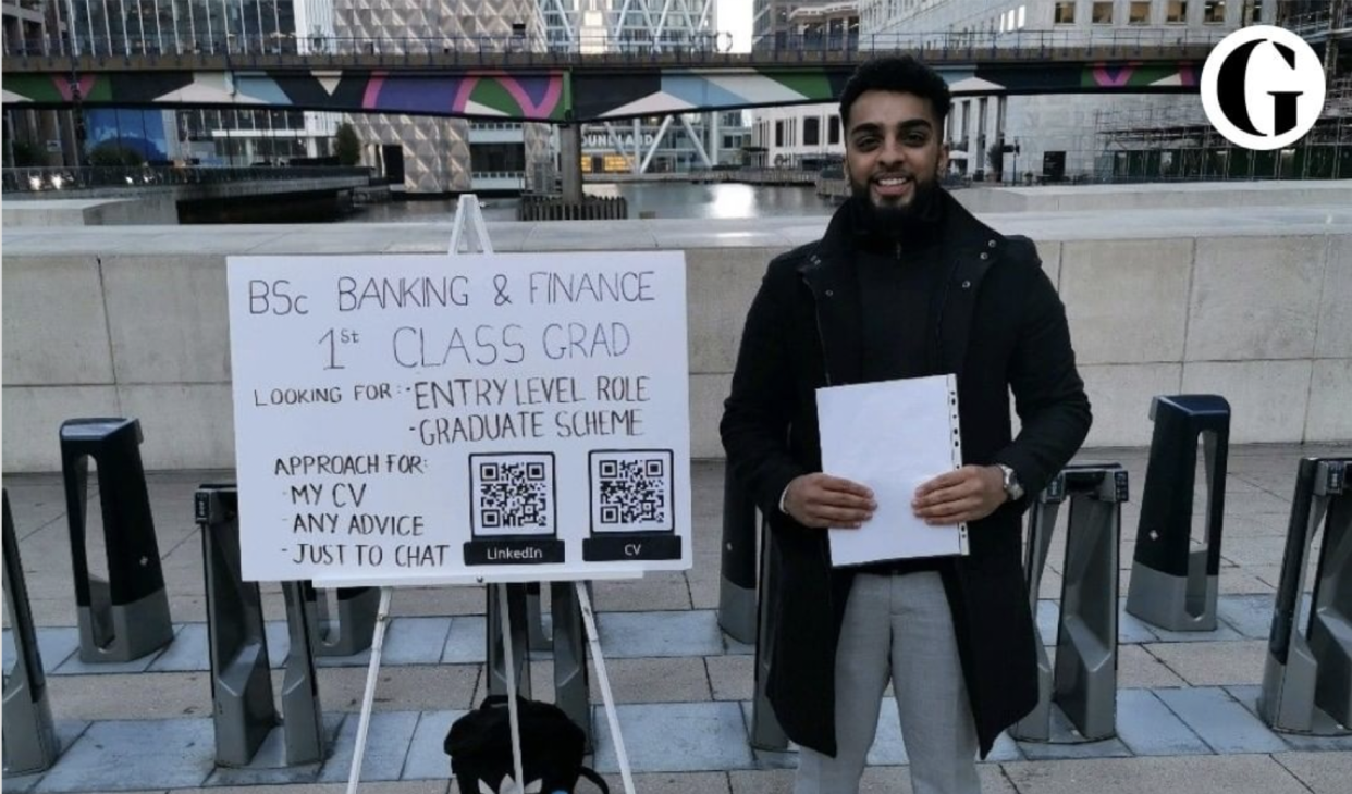 Haider Malik mit seinem Schild in Canary Wharf.