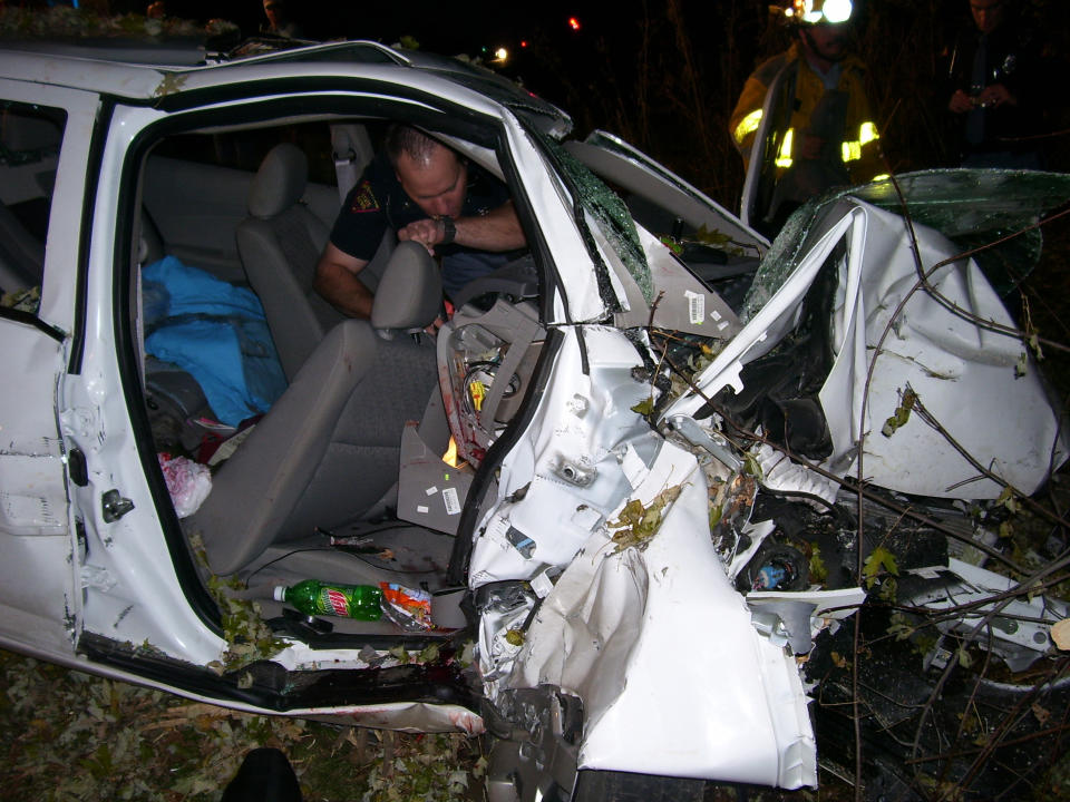 In this 2006 photo, police investigate the wreckage of a 2005 Chevrolet Cobalt that crashed in Wisconsin, killing two teenagers and injuring another. (AP Photo/St. Croix County Sheriff's Office)