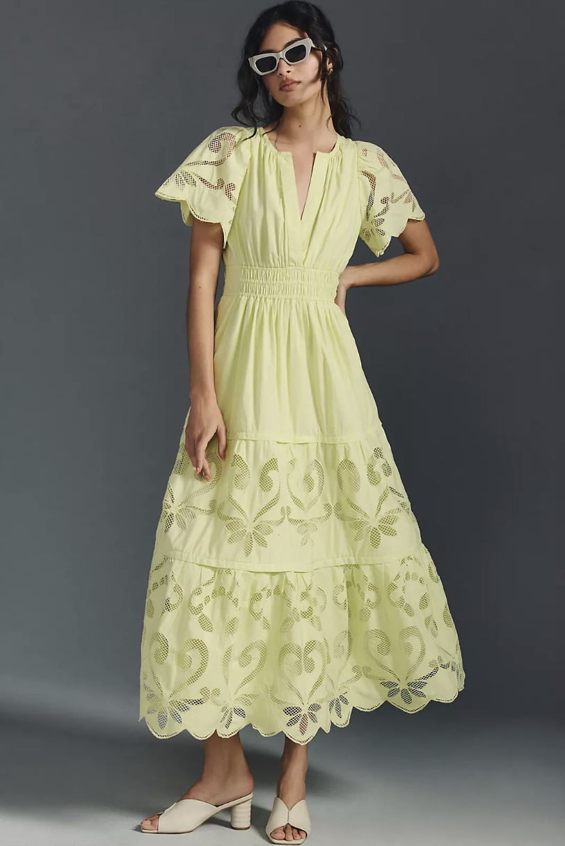 brunette model wearing sunglasses, white sandals, and light green The Somerset Maxi Dress: Cutwork Edition in green (photo via Anthropologie)