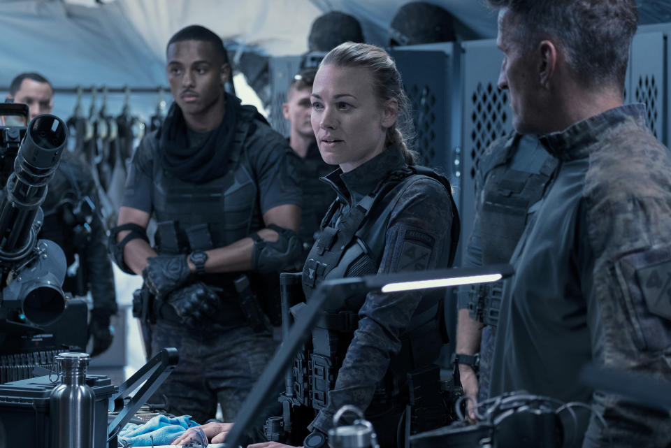 This image released by Amazon shows Keith Powers, background left, and Yvonne Strahovski, center, in a scene from "The Tomorrow War." (Frank Masi/Amazon via AP)