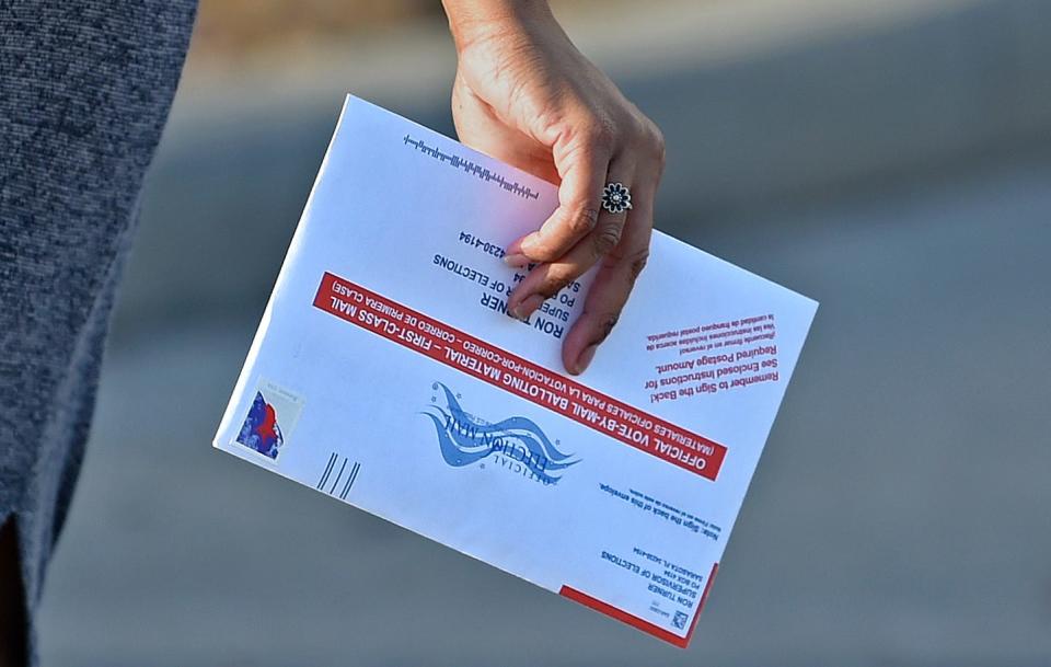 A voter drops off her ballot at the Supervisor of Elections office in Sarasota during the March 8 election.