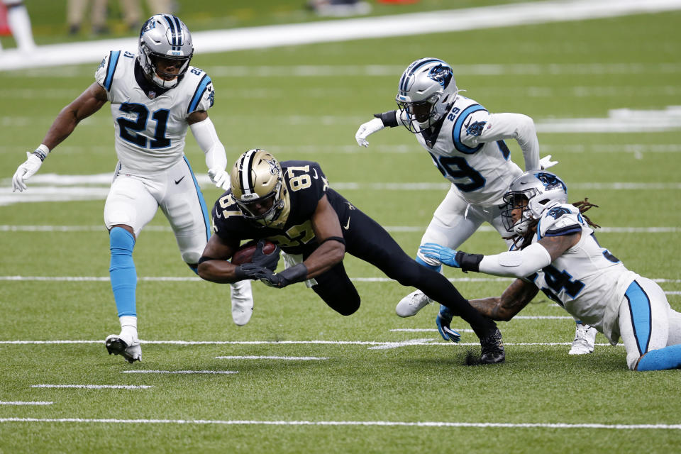 New Orleans Saints tight end Jared Cook (87) is brought down by Carolina Panthers outside linebacker Shaq Thompson (54), cornerback Corn Elder (29) and outside linebacker Jeremy Chinn (21) in the first half of an NFL football game in New Orleans, Sunday, Oct. 25, 2020. (AP Photo/Brett Duke)