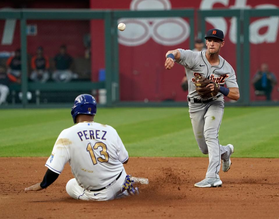 Tigers shortstop Zack Short throws over Royals catcher Salvador Perez as he tries to turn a double play in the fourth inning on Friday, July 23, 2021, in Kansas City, Missouri.