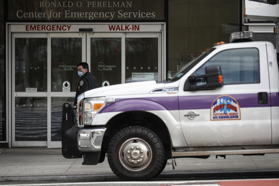 In this March 16, 2020, photo an NYPD officer wearing a protective face mask monitors the outside of the NYU Langone Hospital Emergency room entrance in New York. Brooklyn’s district attorney announced Tuesday, March 17, that because of the crisis his office is declining to prosecute low-level offenses that don’t jeopardize public safety. (AP Photo/John Minchillo, File)