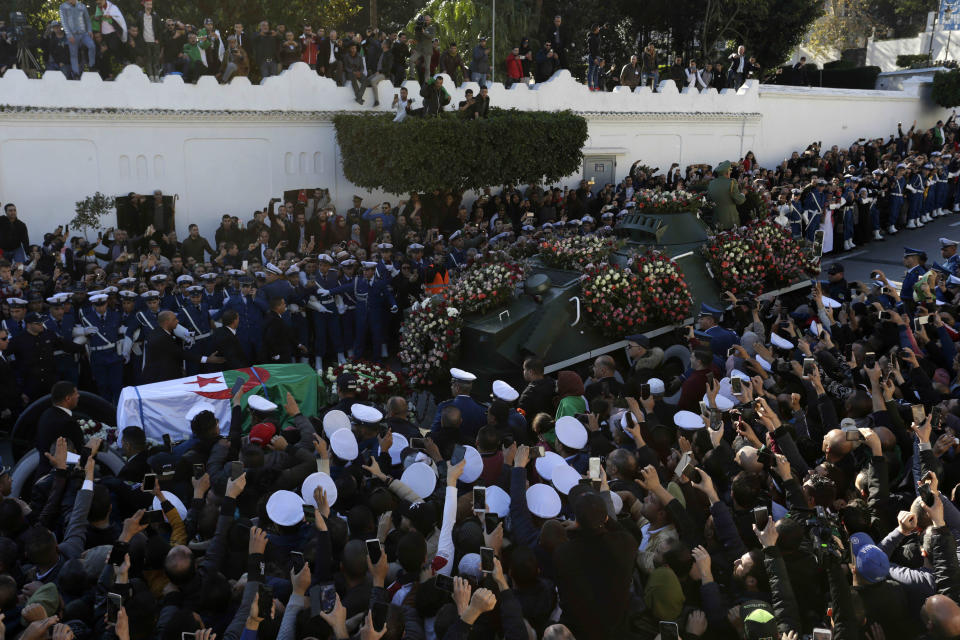 People gather during the funeral Gen. Ahmed Gaid Salah, in Algiers, Algeria, Wednesday, Dec. 25, 2019. Algeria is holding an elaborate military funeral for the general who was the de facto ruler of the gas-rich country amid political turmoil throughout this year. (AP Photo/Toufik Doudou)