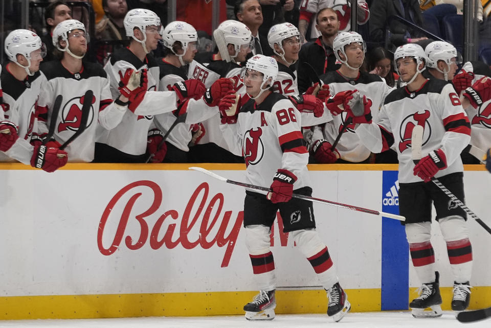 New Jersey Devils center Jack Hughes (86) celebrates a goal with teammates during the second period of an NHL hockey game against the Nashville Predators, Tuesday, Feb. 13, 2024, in Nashville, Tenn. (AP Photo/George Walker IV)