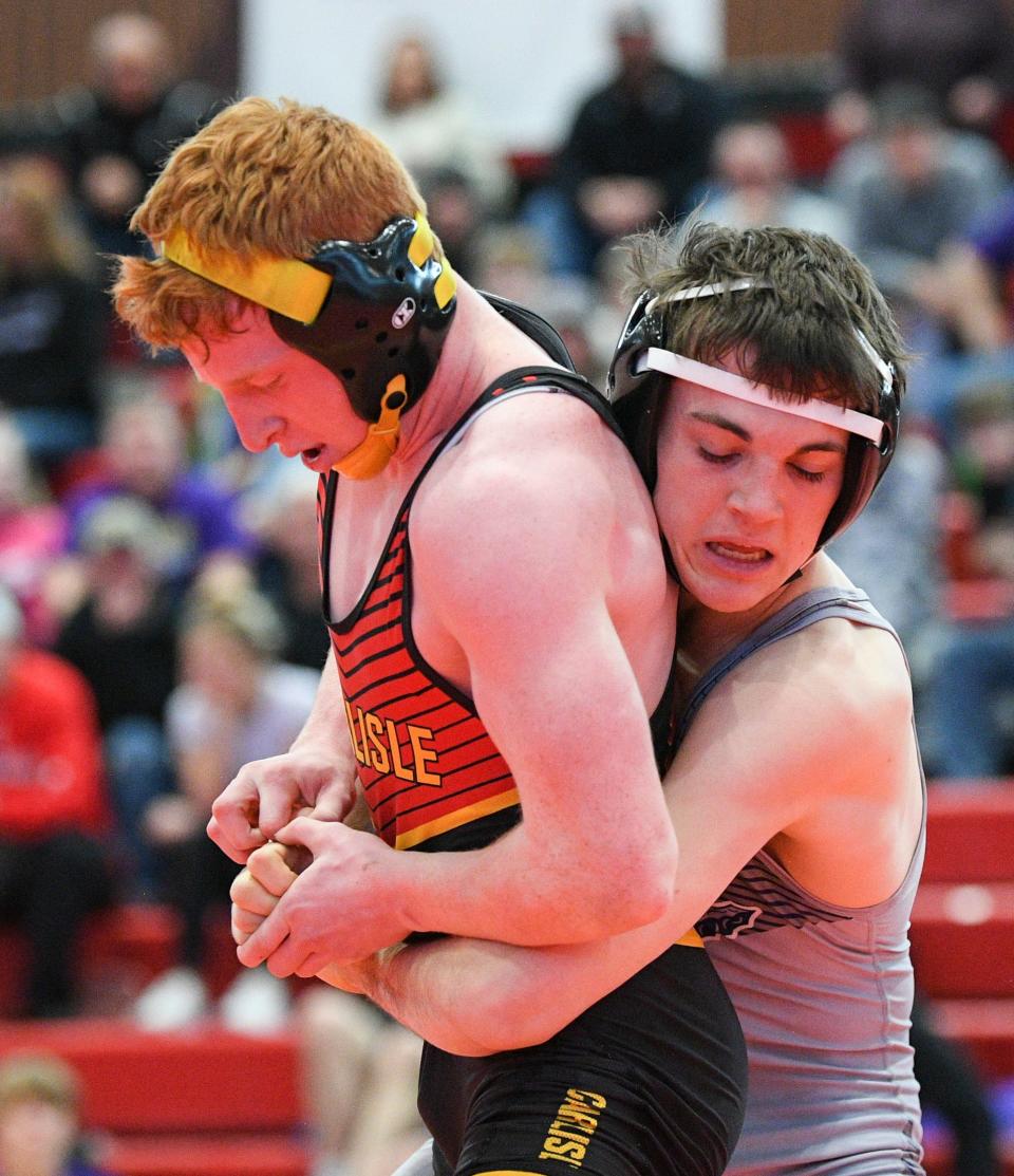 Carlisle's Mason Lucas, left, wrestles Norwalk's Trent Harper at 126 pounds during the Class 3A district tournament at Carlisle High School on Saturday.