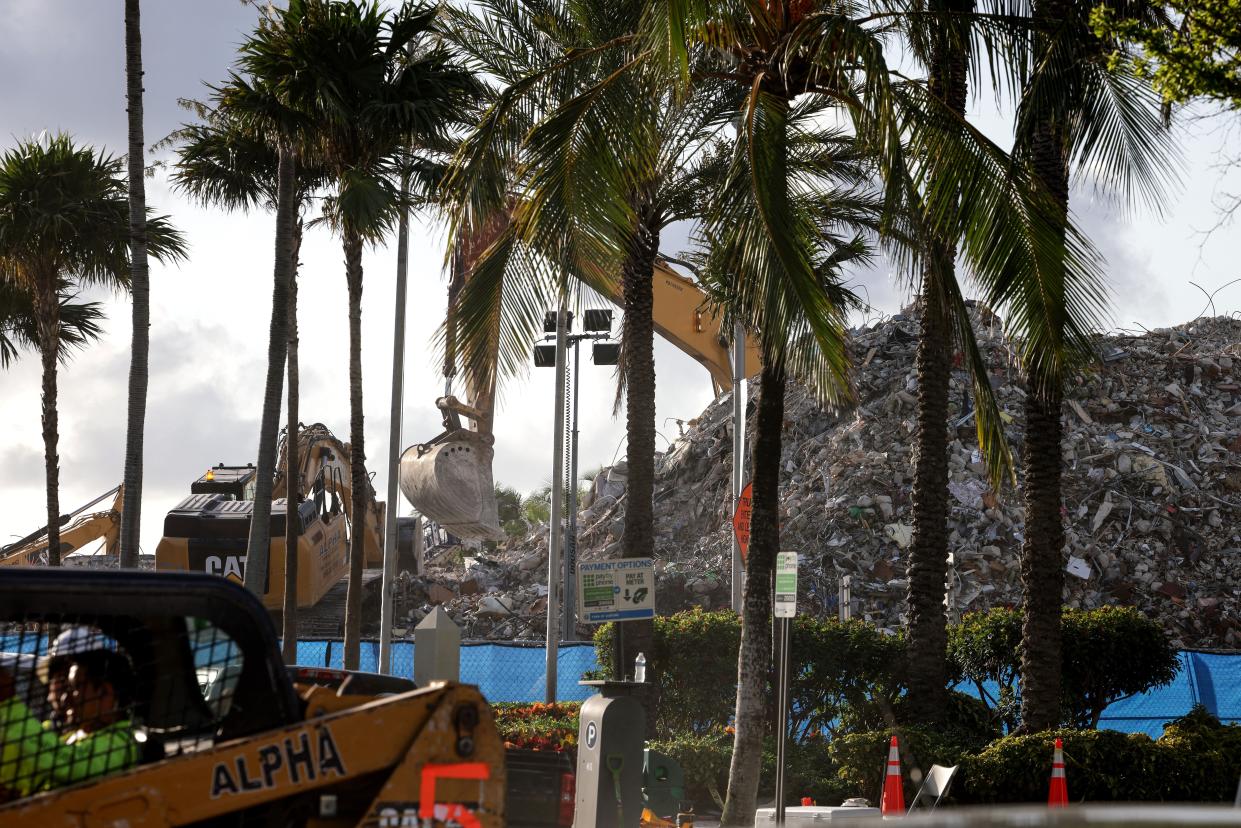 Excavators dig through the pile of debris from the collapsed 12-story Champlain Towers South condo building on July 11, 2021, in Surfside, Fla.