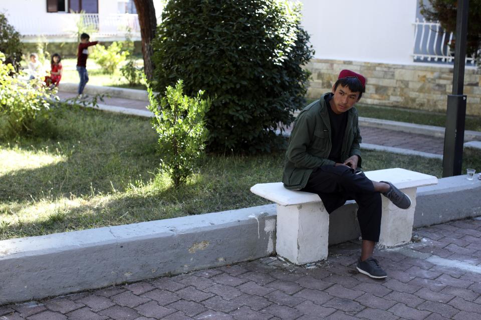 An Afghan teenager sits on a bench at a coastline tourist resort in Golem, 50 kilometers (30 miles) west of Tirana, Albania, Wednesday, Oct. 27, 2021. A group of Afghans evacuated earlier this month are housed at an Albanian coastline tourist resort enjoying the warm welcome and a normal daily life. The last group of judges, sportsmen, journalists, activists, artists, law enforcement officers, scientists and more arrived earlier in October. They all miss and fear of the fate of their families back home. (AP Photo/Franc Zhurda)