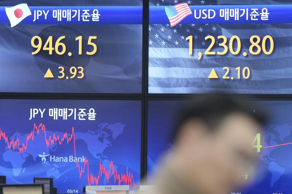 A currency trader walks by the screens showing the foreign exchange rates at a foreign exchange dealing room in Seoul, South Korea, Wednesday, Feb. 1, 2023. Asian stock markets were higher Wednesday after Wall Street rose ahead of what traders hope will be the last Federal Reserve interest rate hike for some time. (AP Photo/Lee Jin-man)