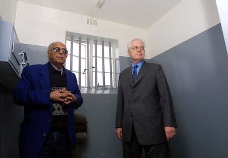 FILE PHOTO: French Prime Minister Lionel Jospin (R) pauses as he listens to former prisoner Ahmed Kathrada (L) near the barred window in the jail cell of former inmate Nelson Mandela a visit of the Robben Island prison, near Cape Town, May 31, 2001. REUTERS/File Photo